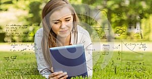 Digitally generated image of various equations with smiling college student using digital tablet in