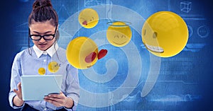 Digitally generated image of woman using tablet computer with emojis flying against tech graphics in