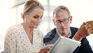 Digitizing bonding time. a mature couple using a digital tablet together at home.