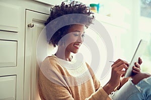 Digitizing her drawings. a young woman using a digital tablet at home.