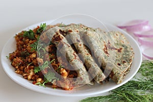 Dil Paratha served with scrambles cottage cheese and garnished with coriander leaves photo