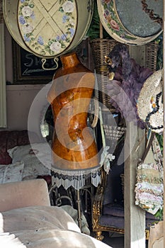 A dilapidated garden room filled with antique furniture