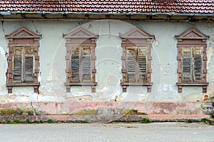Dilapidated house with broken windows and shutters