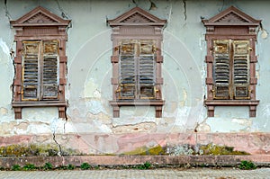 Dilapidated house with broken windows and shutters