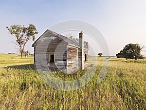 Dilapidated house in field.