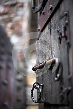 Dilapidated old open wooden vintage door with forged deadbolt an photo