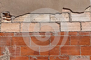 Dilapidated old textured red brick wall background surface is ruptured