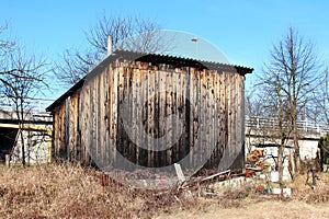 Dilapidated old wooden tool shed and storage area built in abandoned suburban family house backyard