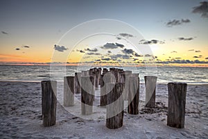 Dilapidated ruins of a pier on Port Royal Beach at sunset