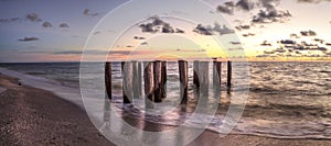 Dilapidated ruins of a pier on Port Royal Beach at sunset