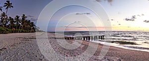 Dilapidated ruins of a pier on Port Royal Beach at sunset