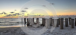 Dilapidated ruins of a pier on Port Royal Beach at sunset