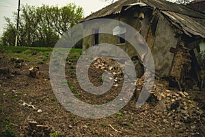 Dilapidated Rural Cottage on a Cloudy Day With Overgrown Vegetation. Abandoned house falling apart with nature taking