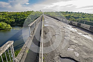 Dilapidated unsafe bridge over river. Abandoned building of emergency condition