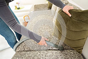 Diligent hand of housewife vacuuming dust photo