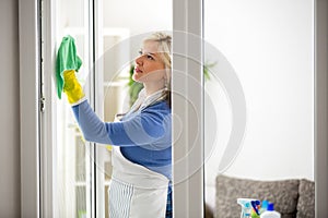 Diligent woman cleans window photo