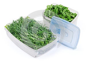 Dill and parsley in two food containers with removed lid