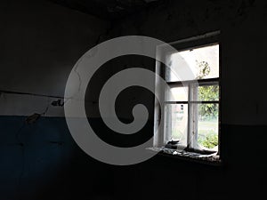 A dim light from the window illuminates an old abandoned room with cracked walls. Gloomy room