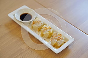 Dim Sum Recipe - Chinese shrimp dumplings topped with fried garlic, served with sour sauce.