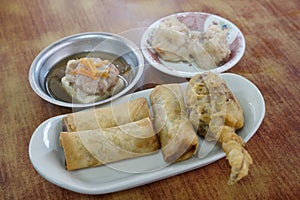 Dim sum steamed shrimp dumpling and Dish of Spring roll and fried crab leg appetize in bowl
