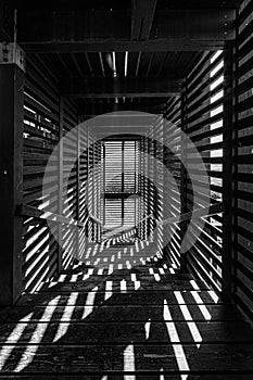 a long hallway with wooden slats leading down into a building