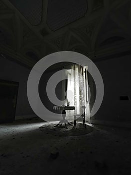 dimly lit room with table and chairs in abandoned house