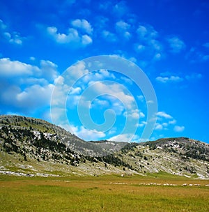 Dinara mountain over blue clouds 1