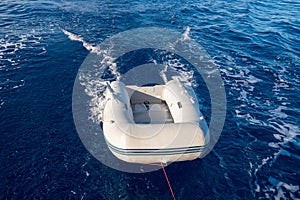 Dinghy (or dingey) inflatable small boat towed by a yacht in the