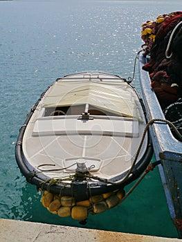 The dinghy by a fishing trawler