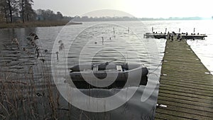 Dinghy inflatable boat in the water at a jetty in a northern German lake