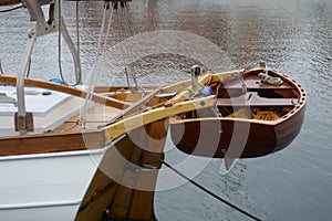 Dinghy, small rowing boat made of mahogany wood, attached to the stern of a sailing yacht