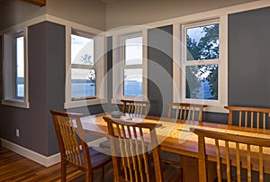 Dining area with wood table and chairs and view windows in contemporary upscale home interior