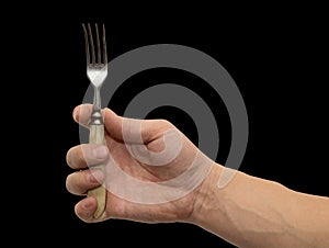Dining fork in hand on a black background