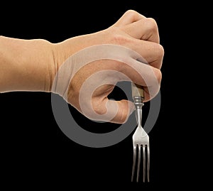 Dining fork in hand on a black background