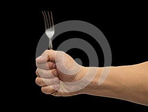 Dining fork in hand on a black background