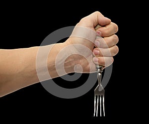 Dining fork in hand on a black background