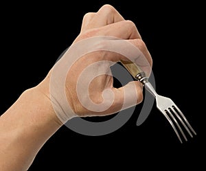 Dining fork in hand on a black background