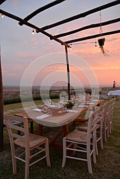 Dining outdoor in Italy. Decked table al fresco by sunset