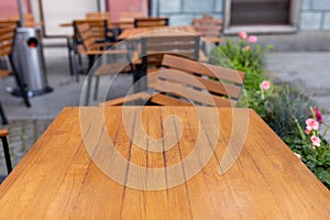 Dining outdoors. Outdoor street cafe tables ready for service. Empty cafe terrace with wooden table and chair. Table of