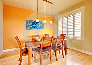 Dining room with blue painting and wood table.