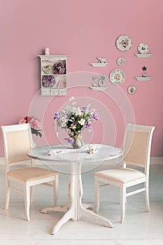 Dining room interior with flowers decorative plates pink wall an