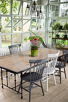 Dining room interior with table, chairs and plants against big w