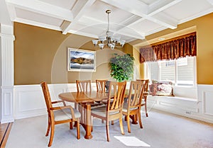 Dining room interior with white bench and wood table.