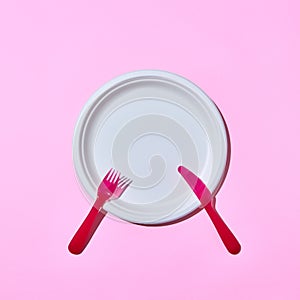 Dining set served fork and knife on pink.