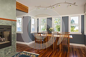 Dining table and chairs with wood floors, painted walls, accent lighting and view windows in contemporary upscale home interior