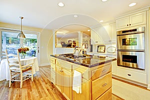 Dining table with classic kitchen yellow walls interior with hardwood floor.