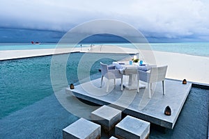 Dining table on the deck of swimming pool