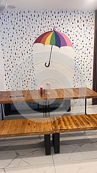 A dining table facing the white designed wall