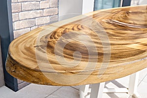 Dining table of live edge suar wood slab on metal carcass in yard