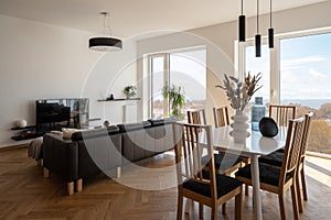 Dining table in living room with big windows
